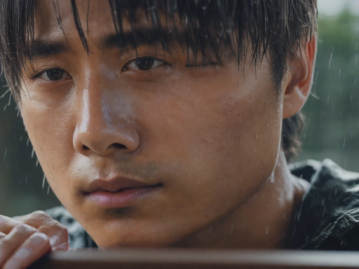 Close-up of an idol sitting by a rainy window, their inner emotions subtly reflected in their gaze and smile.