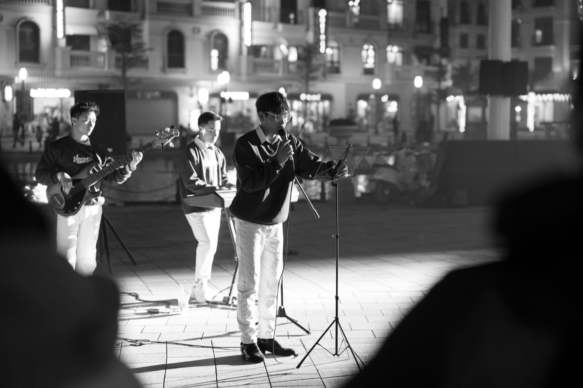 Idole K-pop en costume noir et blanc sur scène