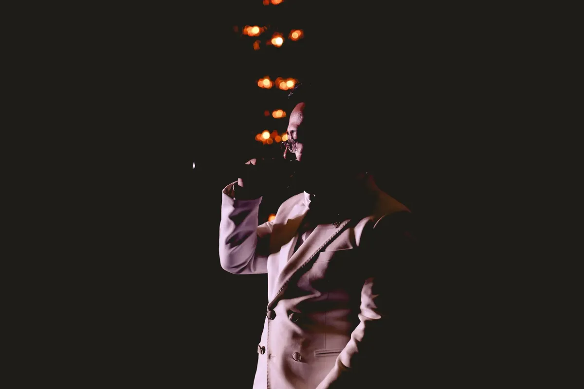A captivating silhouette of a singer on stage with dramatic lighting and ambiance.