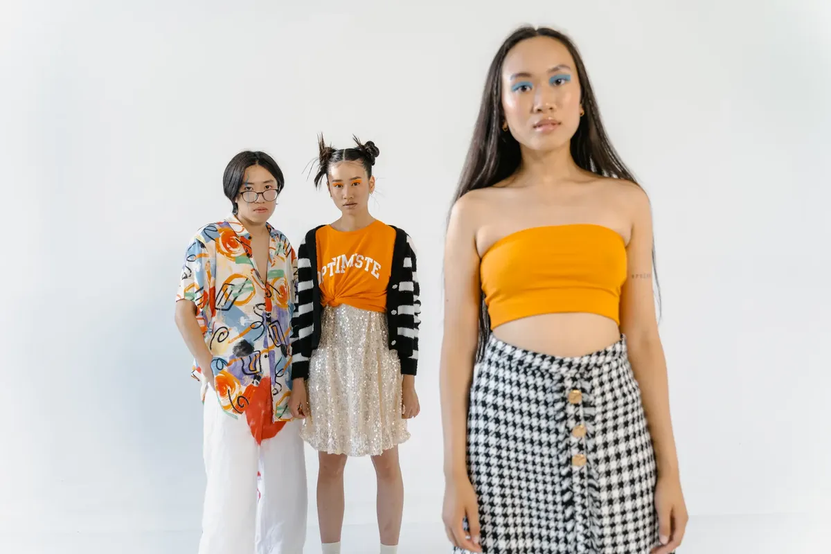 Group of stylish youths in bright attire posing confidently in a studio setting.