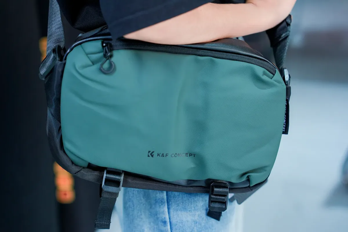 穿著休閒服裝的個人佩戴K&F Concept 綠色攝影包，強調其設計與使用方式